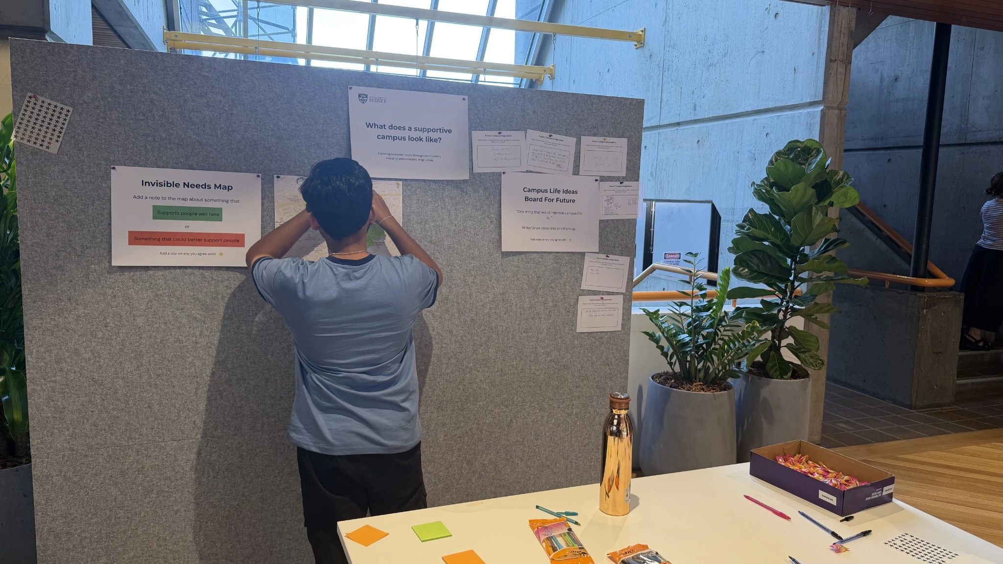 A student pinning a colour-coded response onto the participatory research board